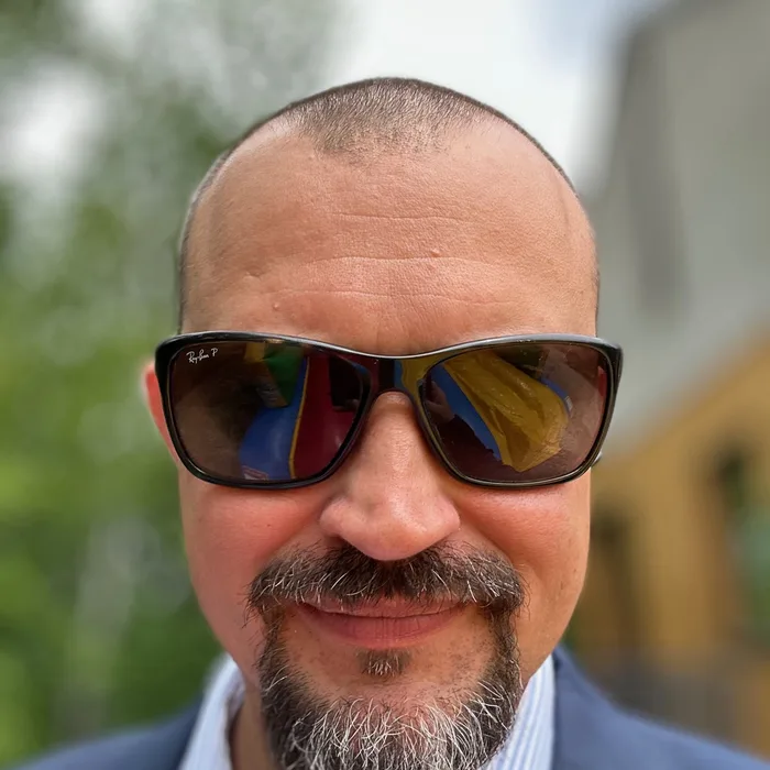 Zdjęcie Krzysztofa Baranowskiego w okularach przeciwsłonecznych.